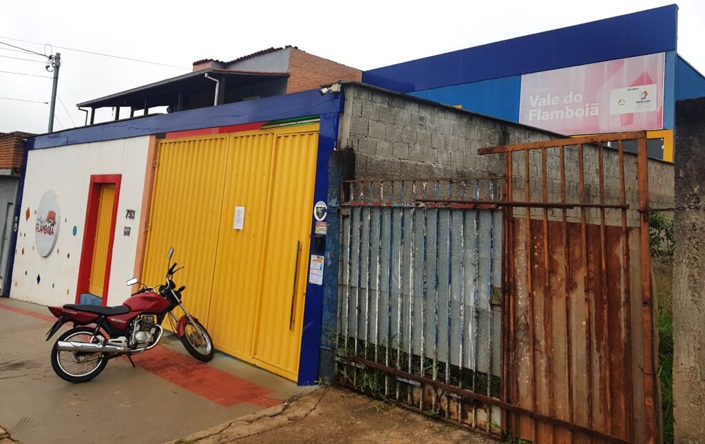 Vista externa da Creche Vale do Flamboiã com placa de identificação do convênio com a Prefeitura de Nova Lima.